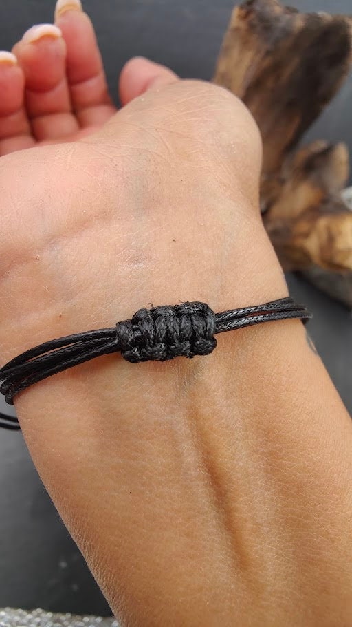 Schwarzes Schnurarmband mit geflochtenem Knoten am Handgelenk getragen – Gedenkschmuck von Zinou Minimanufaktur