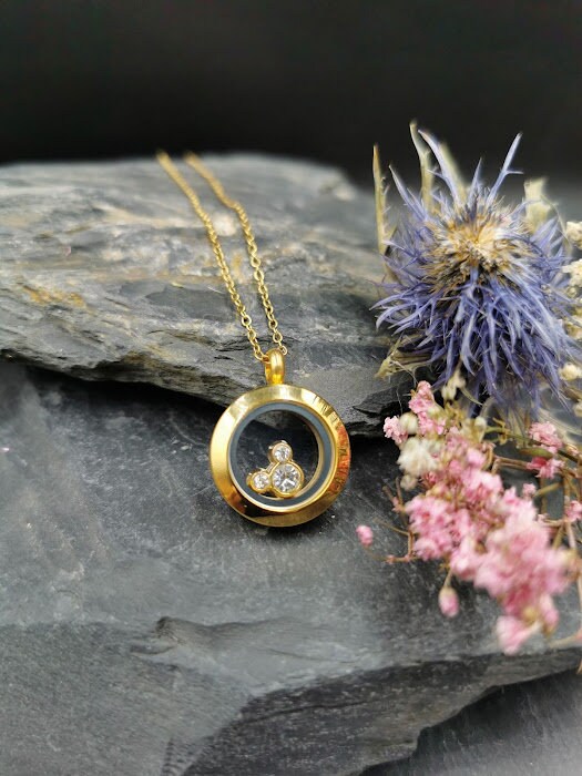 Goldenes Amulett Luna mit 3 funkelnden Kristall-Floating-Charms an Goldkette auf Schieferstein mit Trockenblumen – Gedenkschmuck von Zinou Minimanufaktur