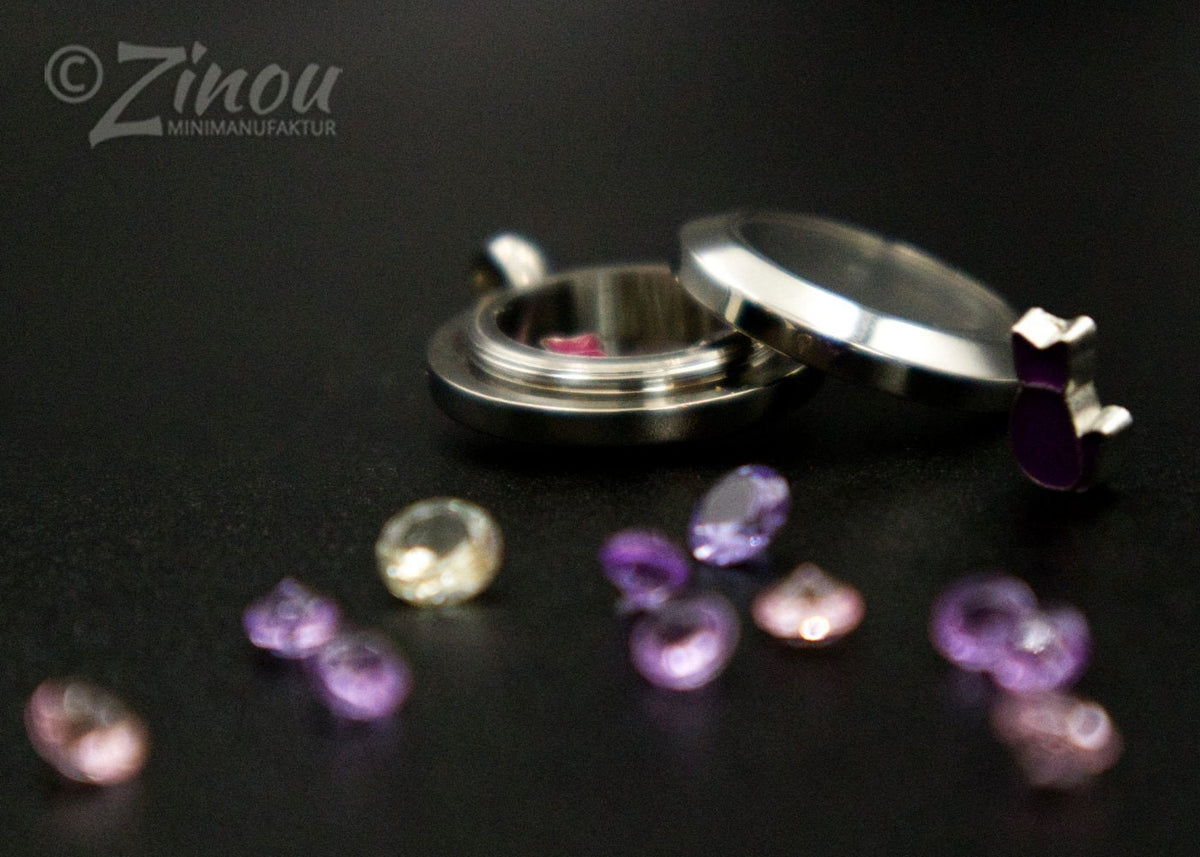 Silbernes Amulett Luna geöffnet mit lila Floating Charms auf schwarzem Hintergrund – Gedenkschmuck von Zinou Minimanufaktur