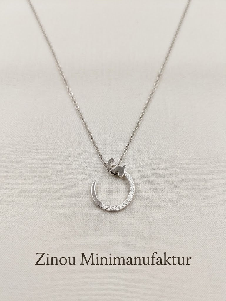  Der Anhänger zeigt einen kleinen, liebevoll ausgearbeiteten Westi auf einem elegant geformten Bogen, der mit feinen, funkelnden Cubic Zirkonia-Steinen besetzt ist.
