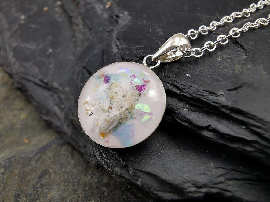 Silberner Dana-Anhänger mit Asche, Opal-Glitter und bunten Partikeln auf Schieferstein, Nahaufnahme – Gedenkschmuck von Zinou Minimanufaktur
Bild 4 (Dana-Anhänger auf Schieferstein neben