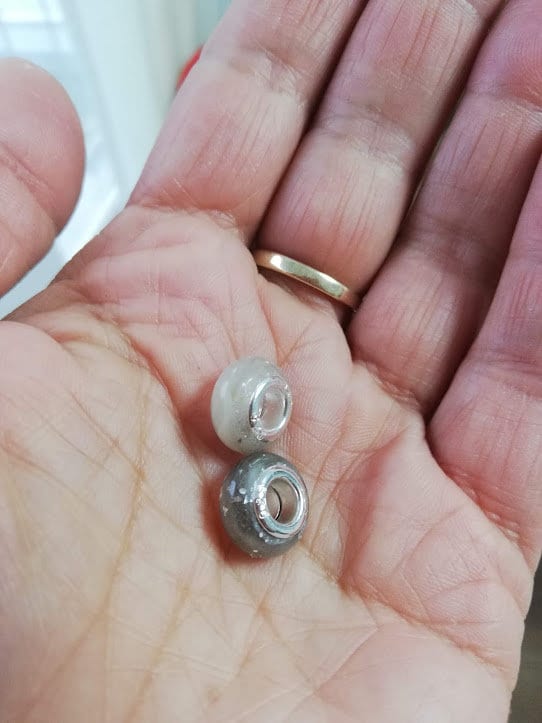 zwei Fellperlen 12mm für Pandora Armband in der Handfläche – creme und grau, handgefertigt von Zinou Minimanufaktur