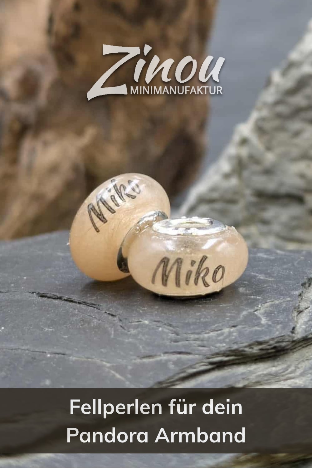 Zwei transparente Gedenkperlen gefüllt mit hellbraunem Tierfell und Namensaufdruck Miko, auf Schieferfelsen präsentiert mit Logo Zinou Minimanufaktur und Text Fellperlen für dein Pandora Armband