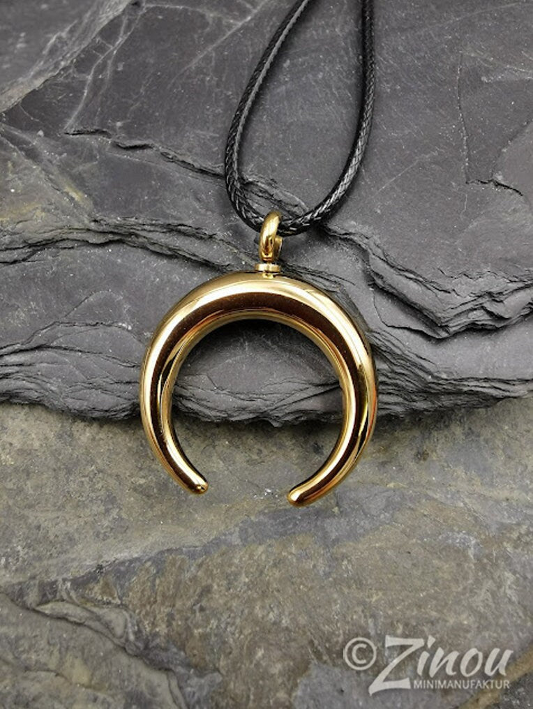 Goldener Edelstahl-Halbmond-Urnenanhänger an schwarzem Lederband auf Schieferstein, Draufsicht – Gedenkschmuck für Asche von Zinou Minimanufaktur