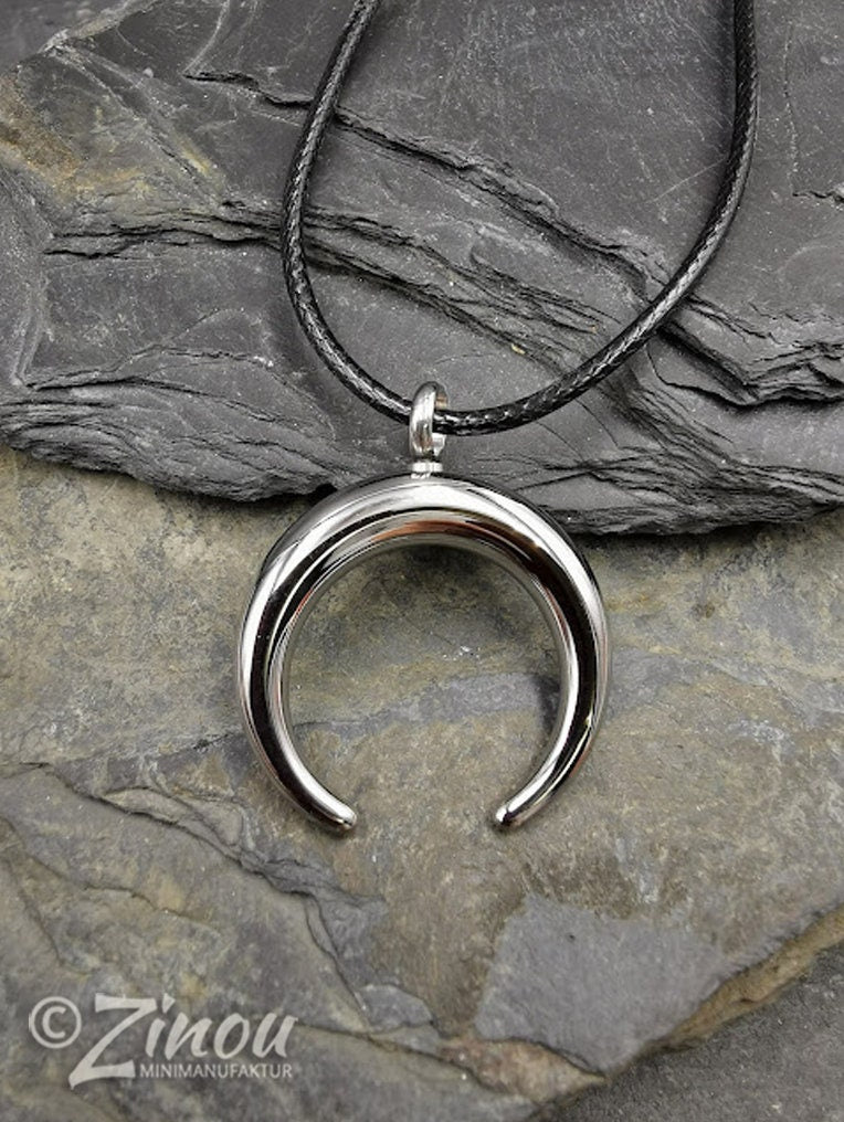 Silberner Edelstahl-Halbmond-Urnenanhänger an schwarzem Lederband auf Schieferstein, Draufsicht – Gedenkschmuck für Asche von Zinou Minimanufaktur