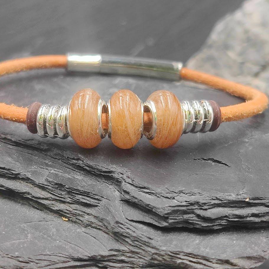 Oranges Creme farbiges Glattlederarmband mit drei orangefarbenen Minifellperlen auf Schieferstein – Zinou Minimanufaktur