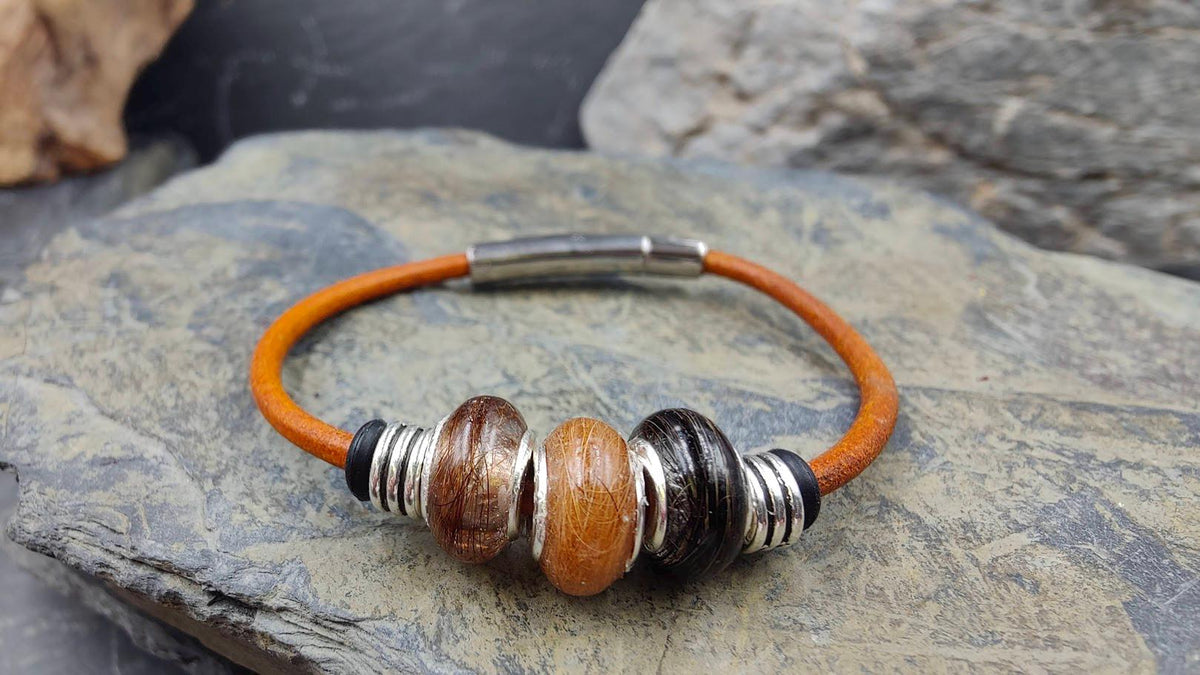 Oranges Glattlederarmband mit drei Minifellperlen in braun, orange und schwarz auf Schieferstein – Zinou Minimanufaktur