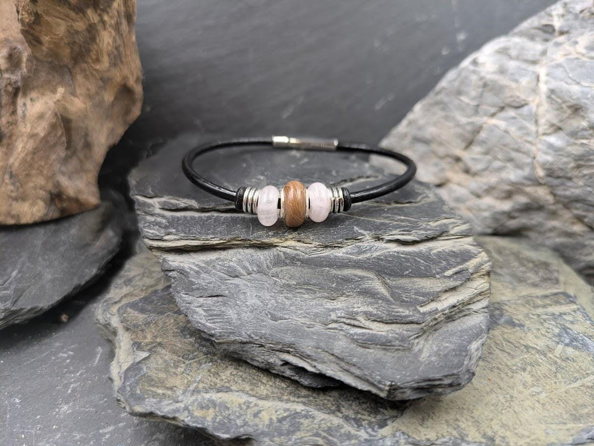 Glücksbringer Armband Lucky mit Fellperle und rosafarbenen Rosenquarz-Perlen auf schwarzem Lederband zwischen Schiefersteinen – Tierhaarschmuck von Zinou Minimanufaktur