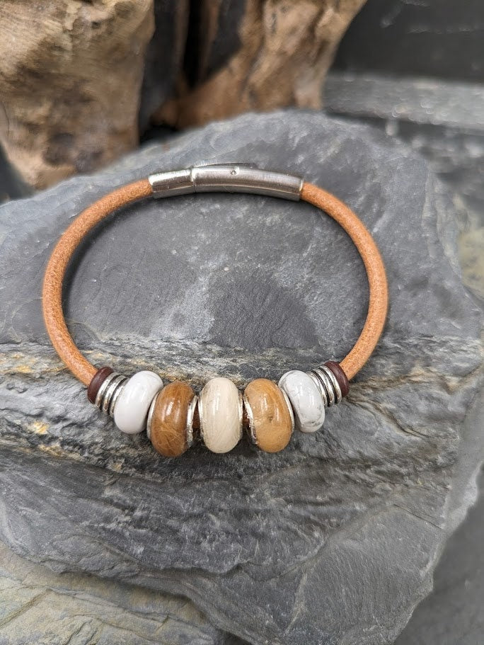 Glücksbringer Armband Lucky mit mehreren Fellperlen und weißen Perlen auf naturbraunem Lederband auf Schieferstein – Tierhaarschmuck von Zinou Minimanufaktur
