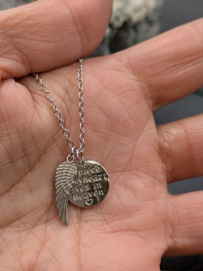 Silberne Heaven-Kette mit Flügel-Charm in der Hand gehalten, seitliche Ansicht – Gedenkschmuck von Zinou Minimanufaktur