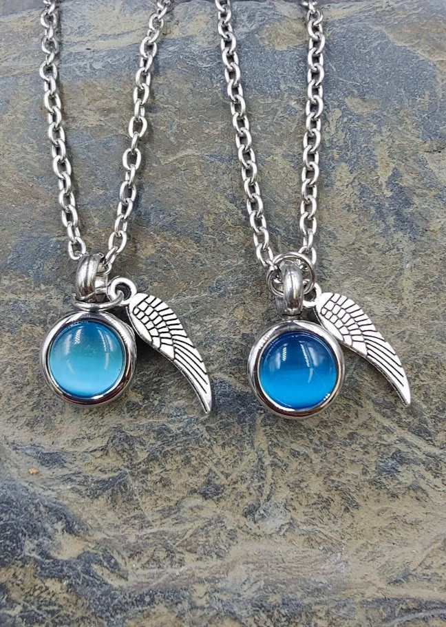 Miniurnen-Anhänger Leni mit dunkelblauer Kugel und Flügel-Charm an Silberkette auf Schieferstein – Gedenkschmuck von Zinou Minimanufaktur