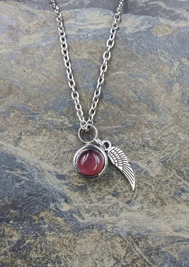 Miniurnen-Anhänger Leni mit dunkelrosafarbener Granat-Kugel und Flügel-Charm an Silberkette auf Schieferstein – Gedenkschmuck von Zinou Minimanufaktur