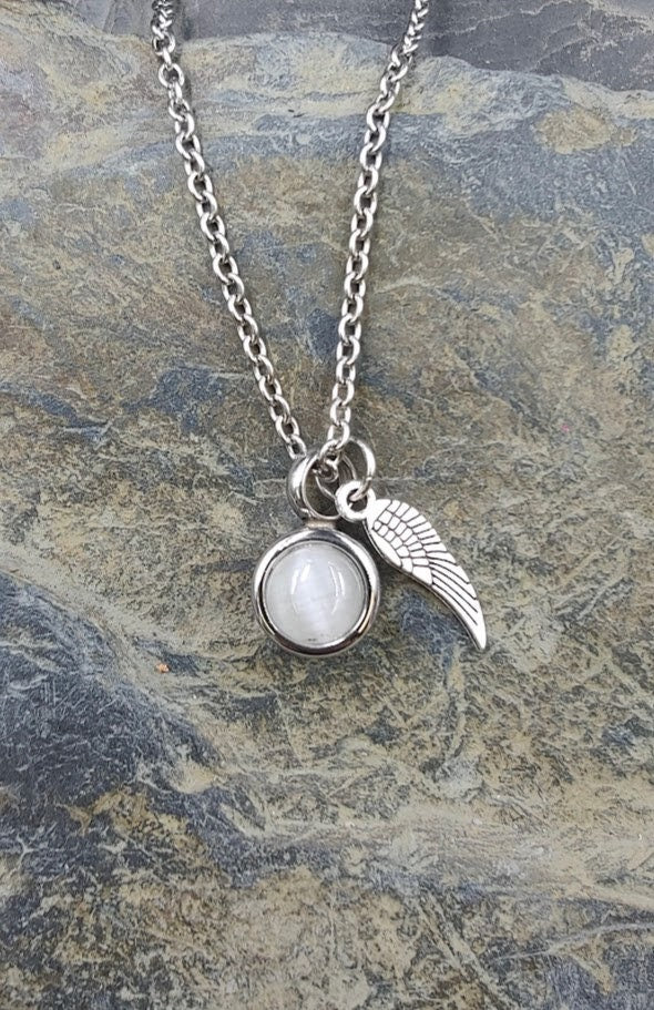 Miniurnen-Anhänger Leni mit weißer Perlmutt-Kugel und Feder-Charm an Silberkette auf Schieferstein – Gedenkschmuck von Zinou Minimanufaktur