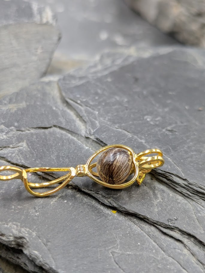Goldener Käfig mit Schmetterling mit kleinen Zirkonia Mitte eine 8mm Perle gefüllt mit Fell oder Asche Untergrund Schiefertafel 