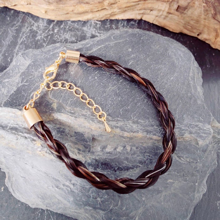Geflochtenes dunkelbraunes Pferdehaararmband mit goldenem Verschluss auf Schieferstein – Zinou Minimanufaktur