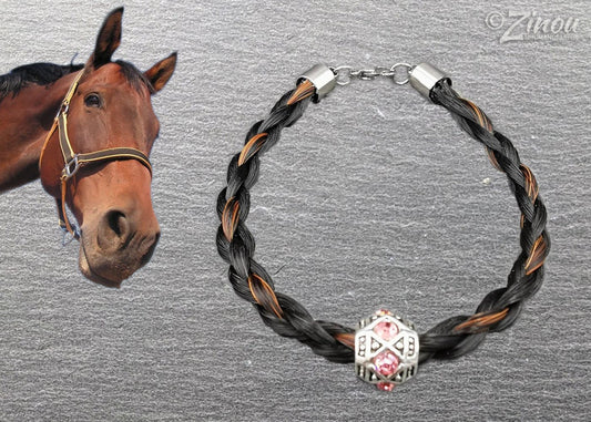 Geflochtenes schwarz-braunes Pferdehaararmband mit silberner Perle und rosafarbenen Strasssteinen auf grauem Hintergrund, braunes Pferd im Bild – Pferdehaarschmuck von Zinou Minimanufaktur
