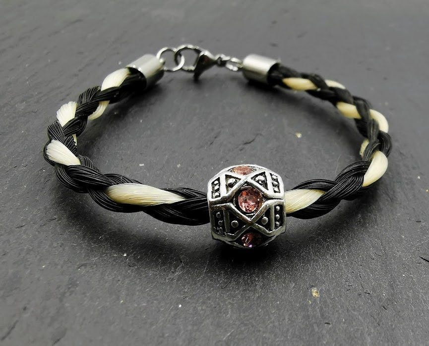 Geflochtenes schwarzwei´ßes Pferdehaararmband mit silberner Perle und rosafarbenen Strasssteinen auf Schieferstein, Frontansicht mit Sielberverschluss – Pferdehaarschmuck von Zinou Minimanufaktur