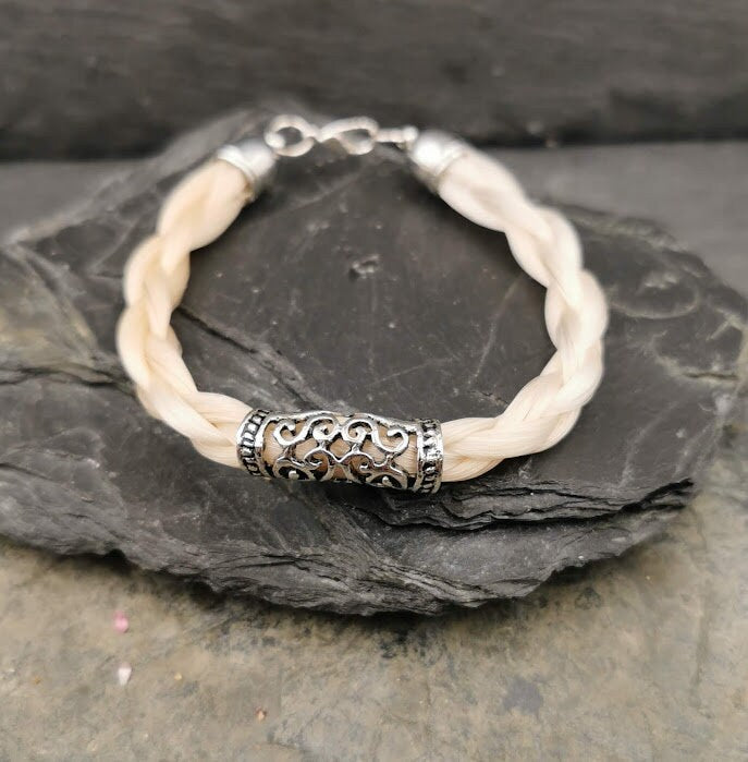 Geflochtenes Pferdehaararmband mit silberner ornamentaler Dreadperle auf Schieferstein, Frontansicht – Pferdehaarschmuck von Zinou Minimanufaktur