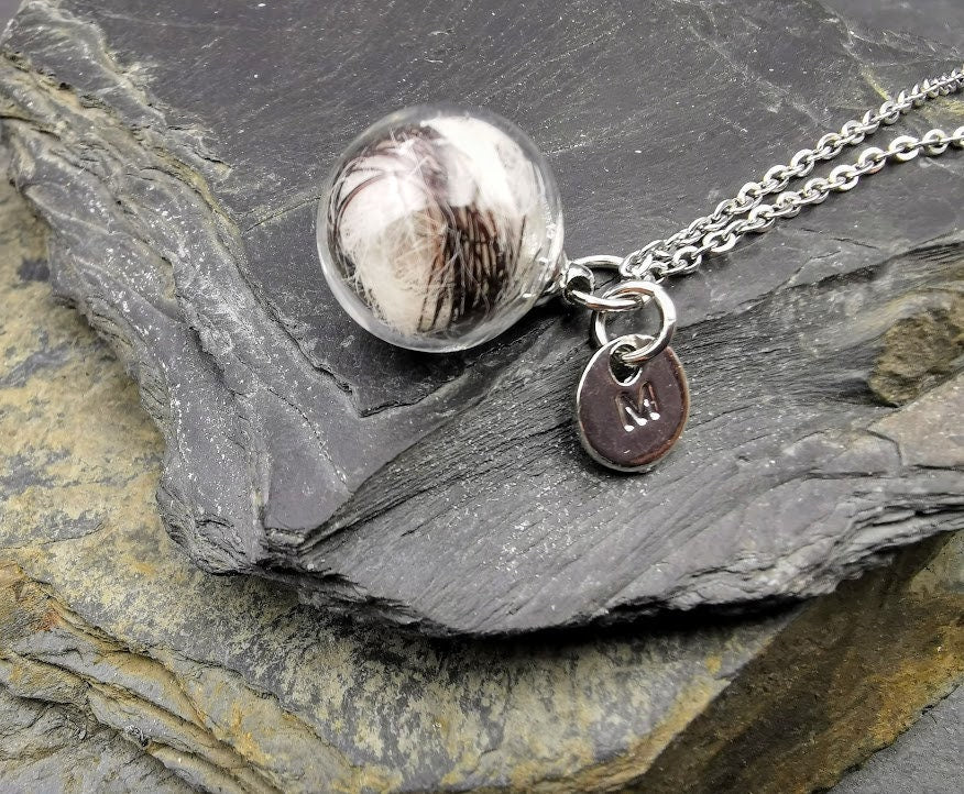 Glasphiole mit Tierhaar und silbernem Buchstaben-Charm M an Silberkette auf Schieferstein, Nahaufnahme – personalisierter Gedenkschmuck von Zinou Minimanufaktur