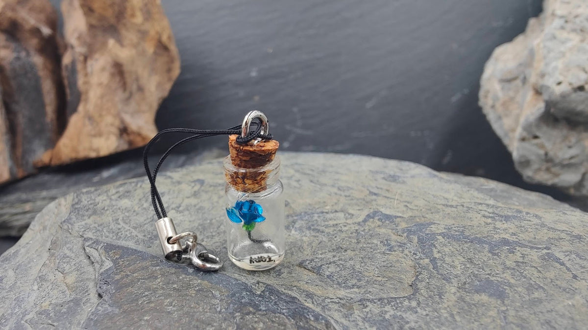 Glasphiole mit blauer Miniatur-Rose im Inneren auf Naturstein – Erinnerungsschmuck DIY von Zinou Minimanufaktur