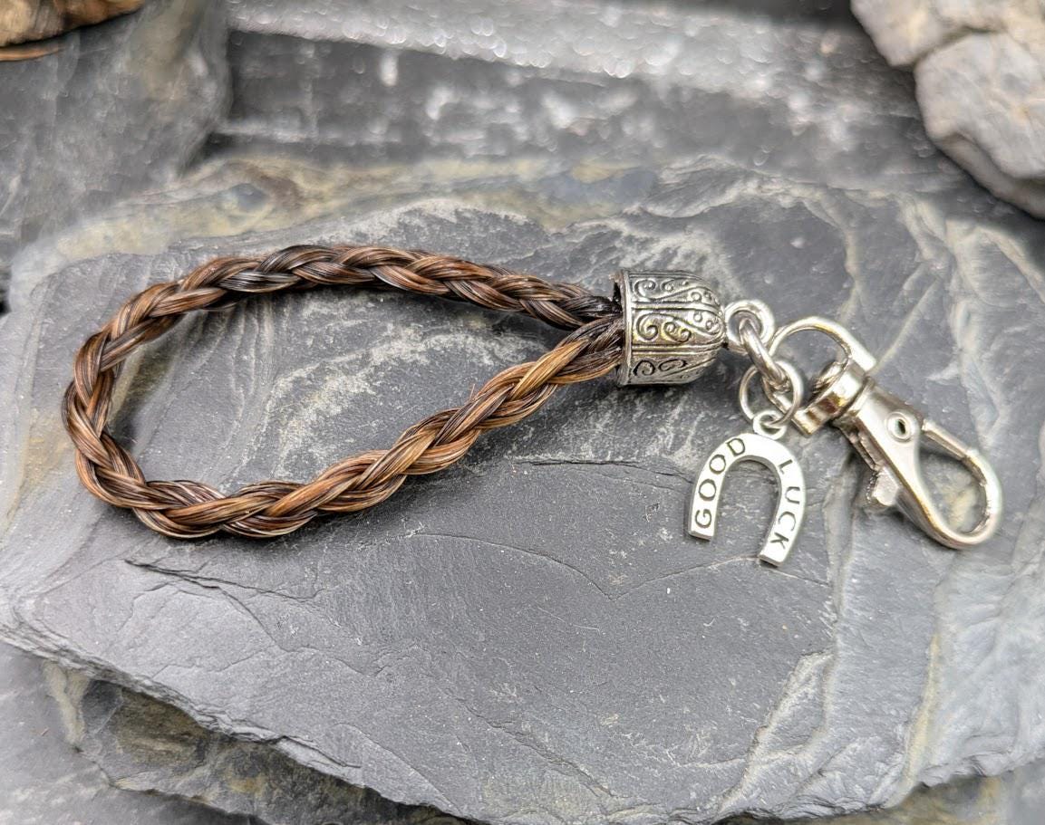 Geflochtener Schlüsselanhänger aus braunem Schweifhaar mit Good-Luck-Hufeisen-Charm – Pferdehaarschmuck von Zinou Minimanufaktur