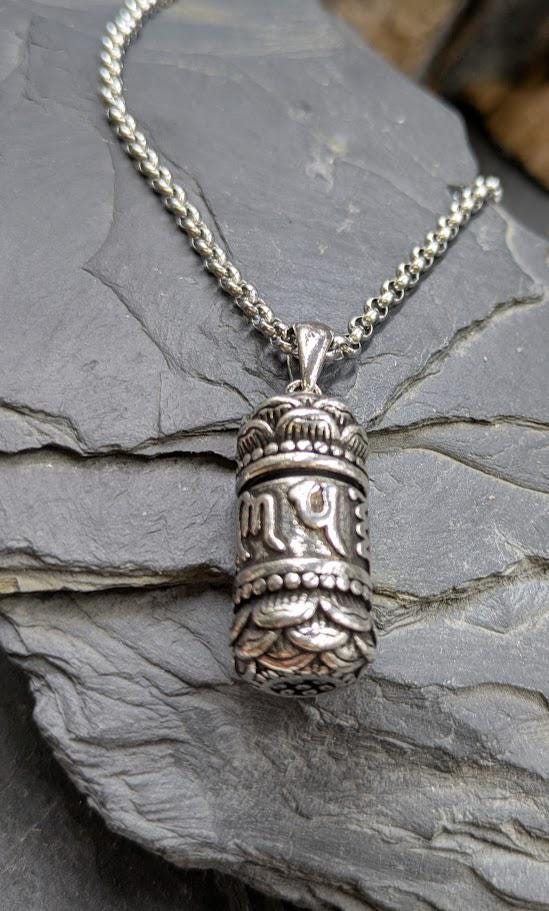 Silberner Shurangma-Mantra-Anhänger an Silberkette auf Schieferstein, Nahaufnahme der tibetischen Mantra-Gravur – Urnenschmuck von Zinou Minimanufaktur
