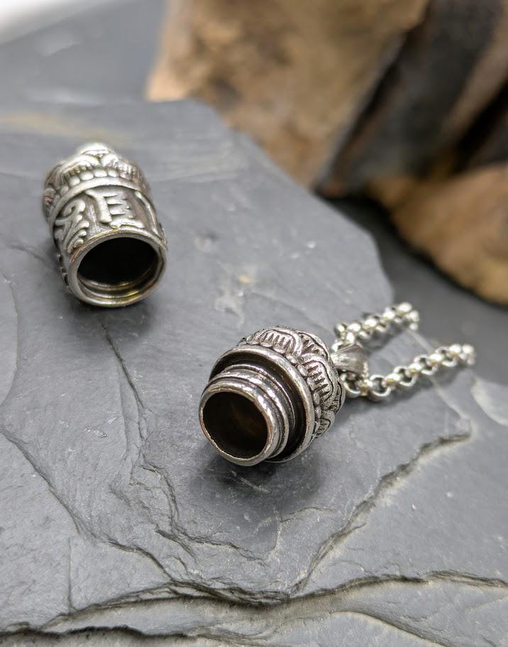 Silberner Shurangma-Mantra-Anhänger aufgeschraubt auf Schieferstein, Innenraum zum Befüllen mit Asche oder Fell sichtbar – Urnenschmuck von Zinou Minimanufaktur