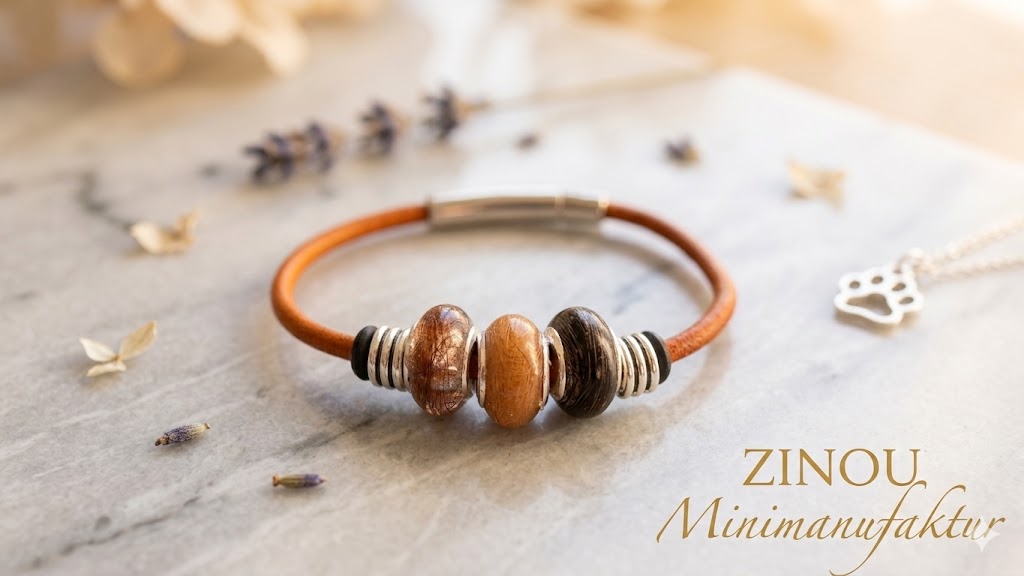 Slick-Armband mit drei braunen und orangefarbenen Fellperlen auf Marmor, Lavendel und Pfoten-Charm im Hintergrund – Tierhaarschmuck von Zinou Minimanufaktur