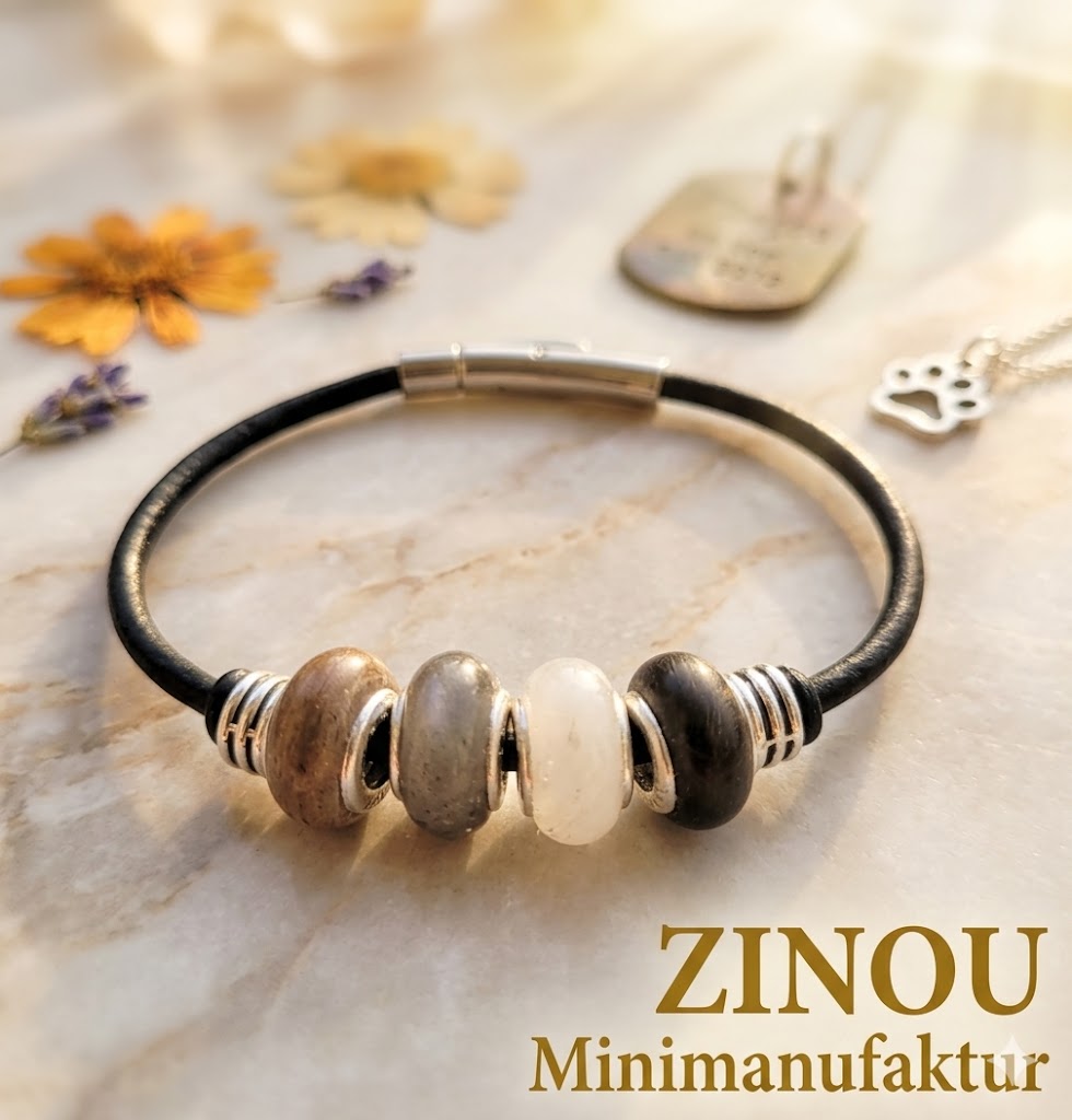 Slick-Armband mit grauen, braunen, schwarzen und weißen Fellperlen an schwarzem Lederband auf Marmor – Tierhaarschmuck von Zinou Minimanufaktur