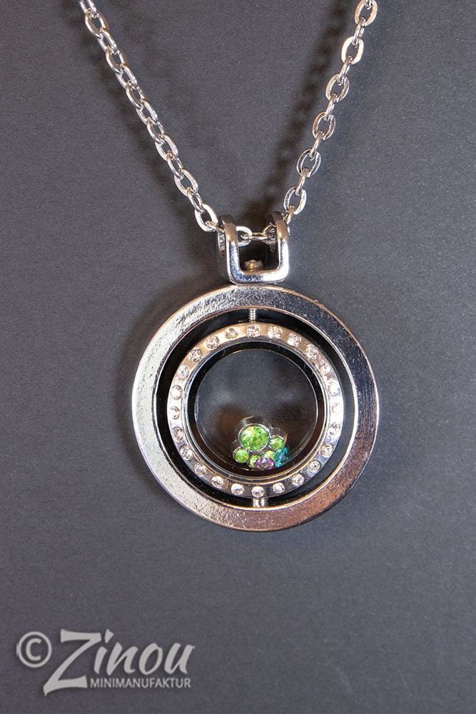 Statement Kette mit silbernem Medaillon und grünen Floating Charms, Frontansicht auf grauem Hintergrund – Zinou Minimanufaktu